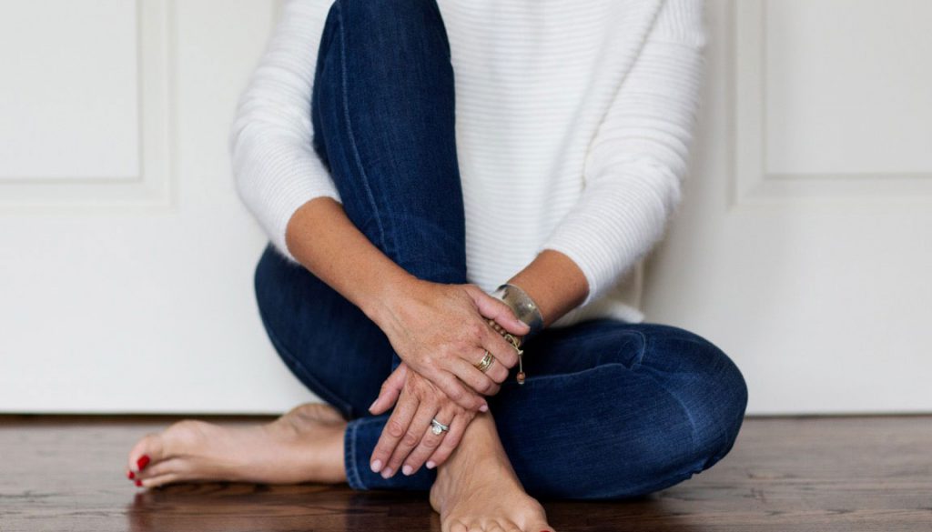 Jessie Carlson wardrobe stylist woman sitting on floor, closeup of her bare feet and hands